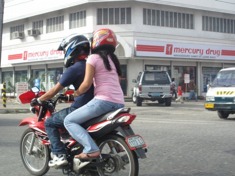 A-couple-wearing-helmets-while-riding-their-motorcycle-along-Matina.jpg